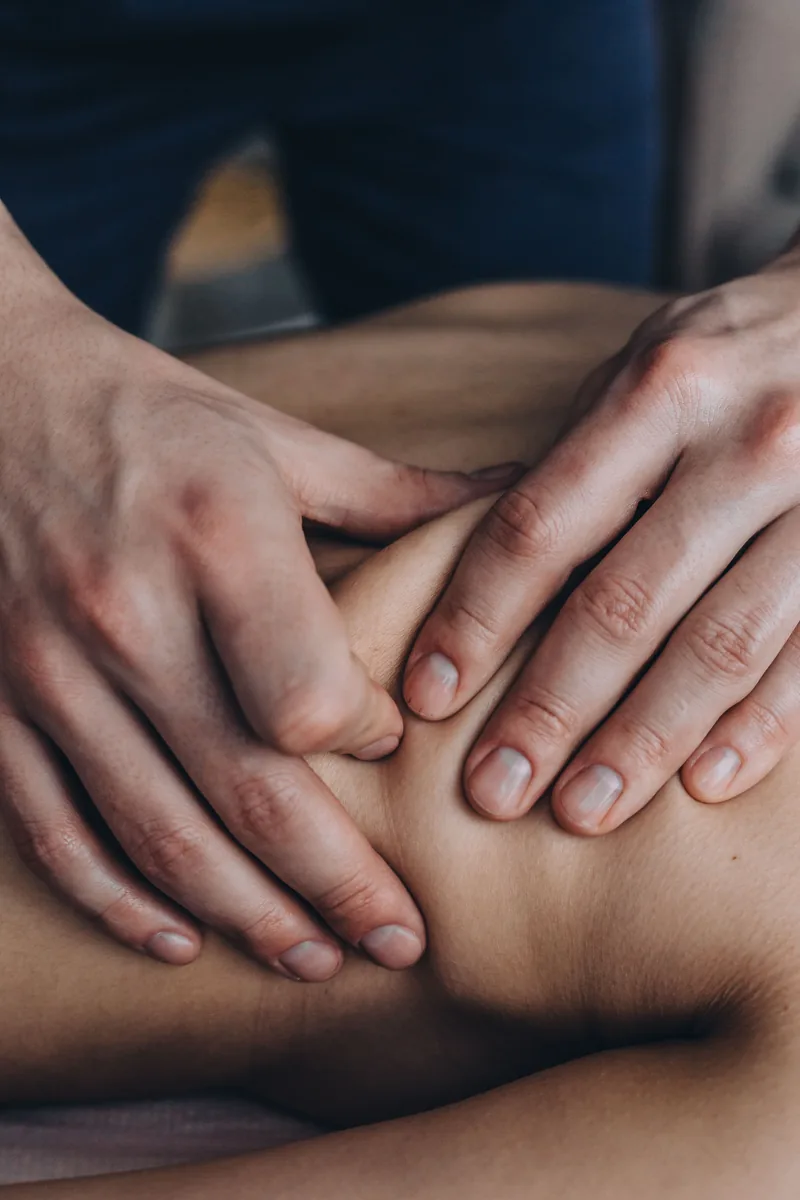 Mãos realizando massagem terapêutica nas costas